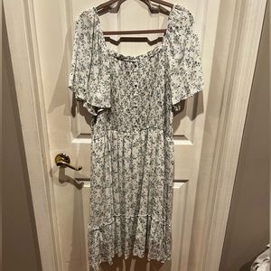 Ivory boutique dress with sage green and blue floral pattern.